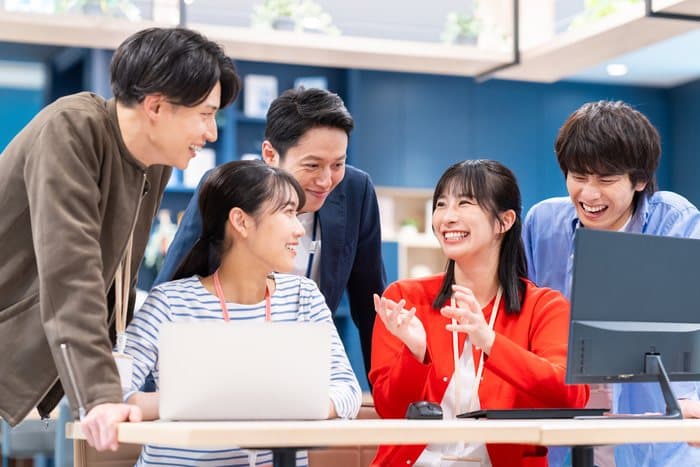 ノートPCを囲んで盛り上がる学生とメンター