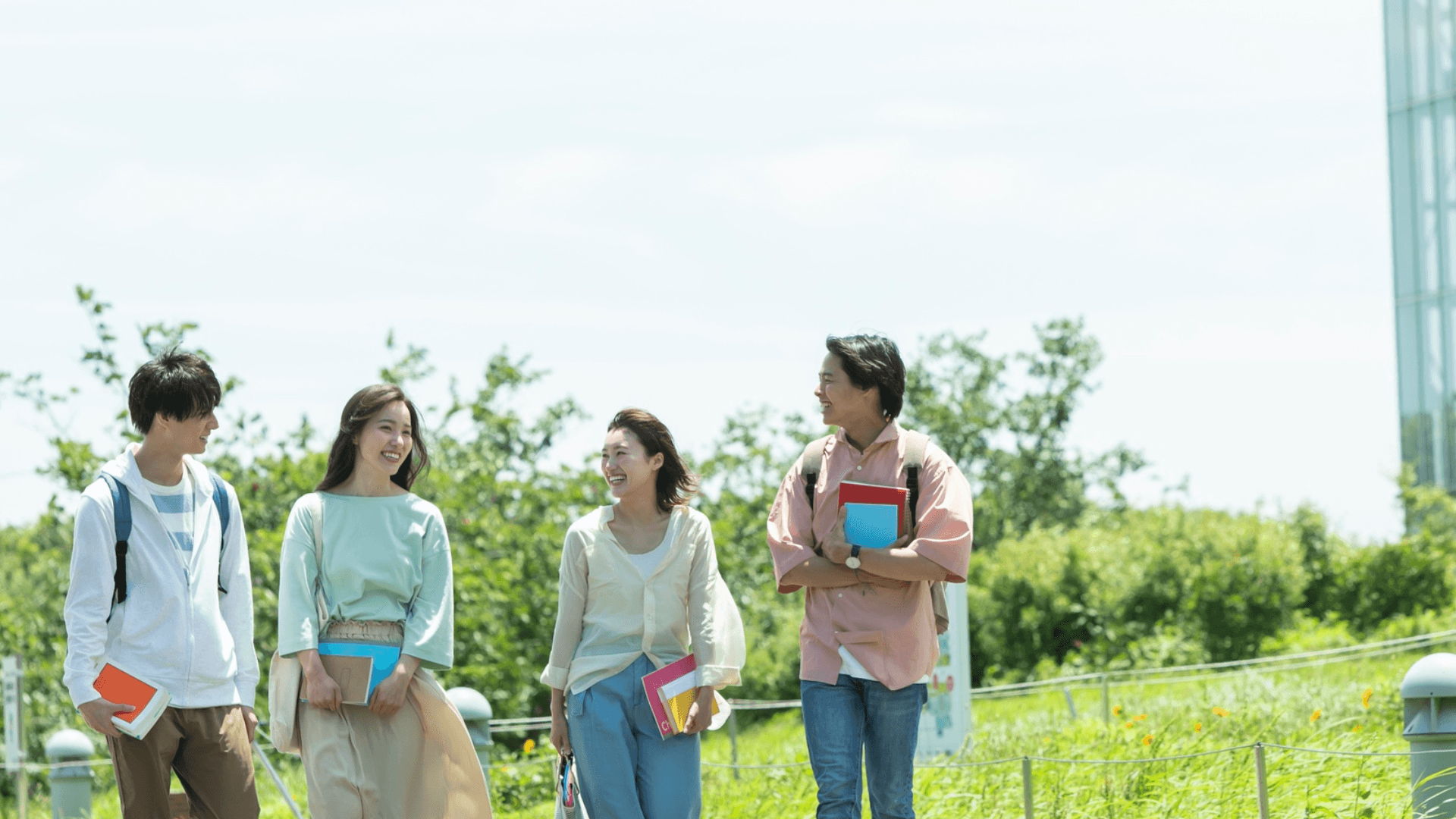 キャンパスで談笑しながら歩くZ世代の大学生たち